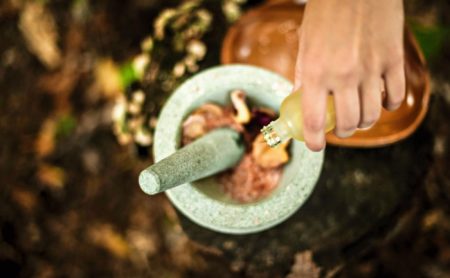 A person is using a mortar and pestle to grind food.