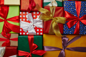 A pile of wrapped presents with bows on them.